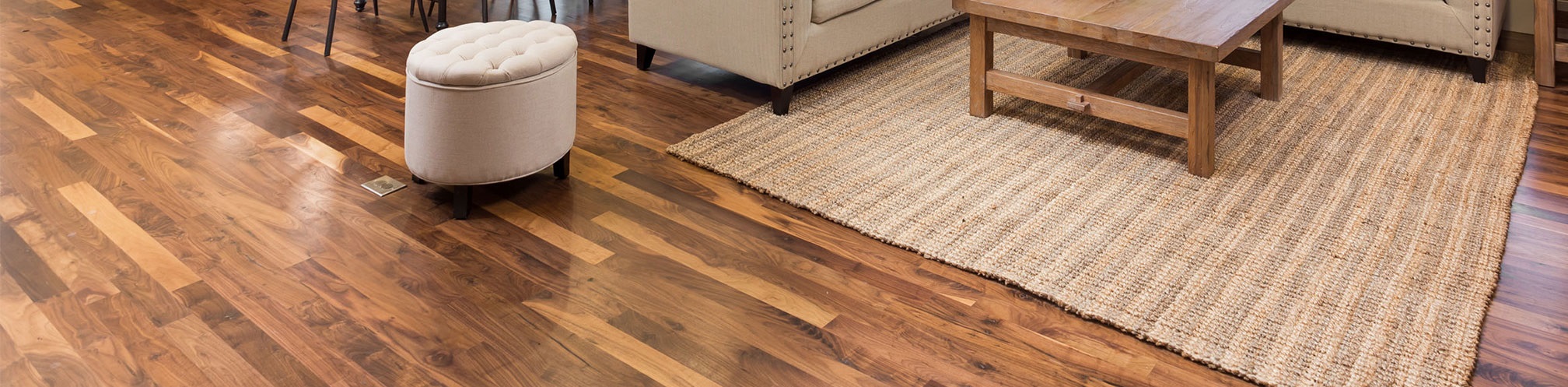 Elegant hardwood flooring in a stylish living room with a woven area rug.