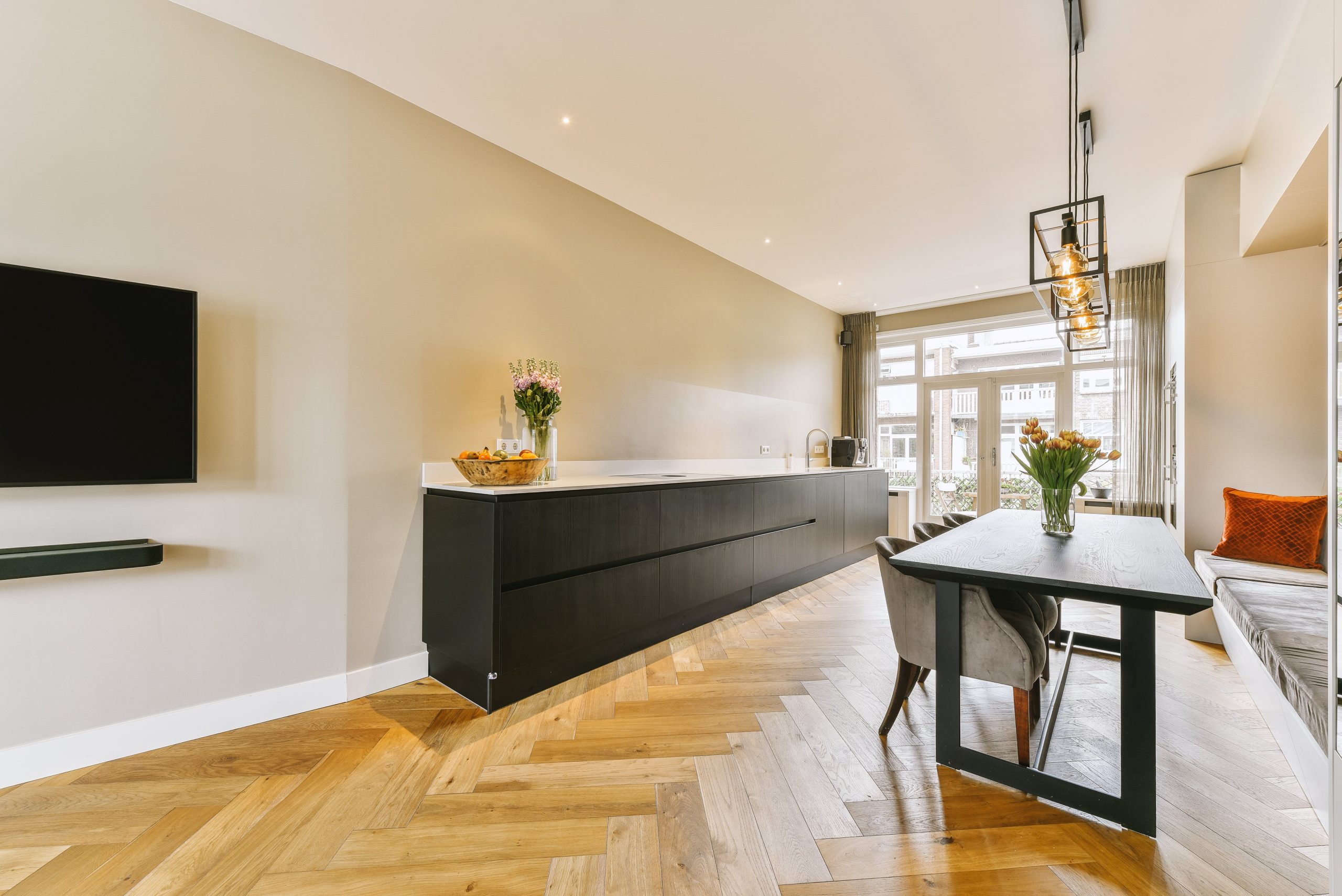 Modern kitchen with stylish herringbone hardwood flooring, blending elegance and durability.