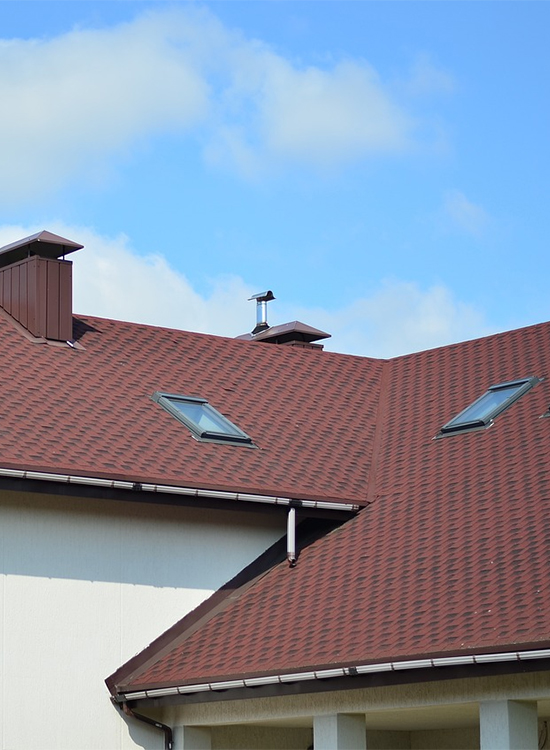 A newly installed brown shingle roof with skylights, designed for durability against coastal weather in Southeastern North Carolina.